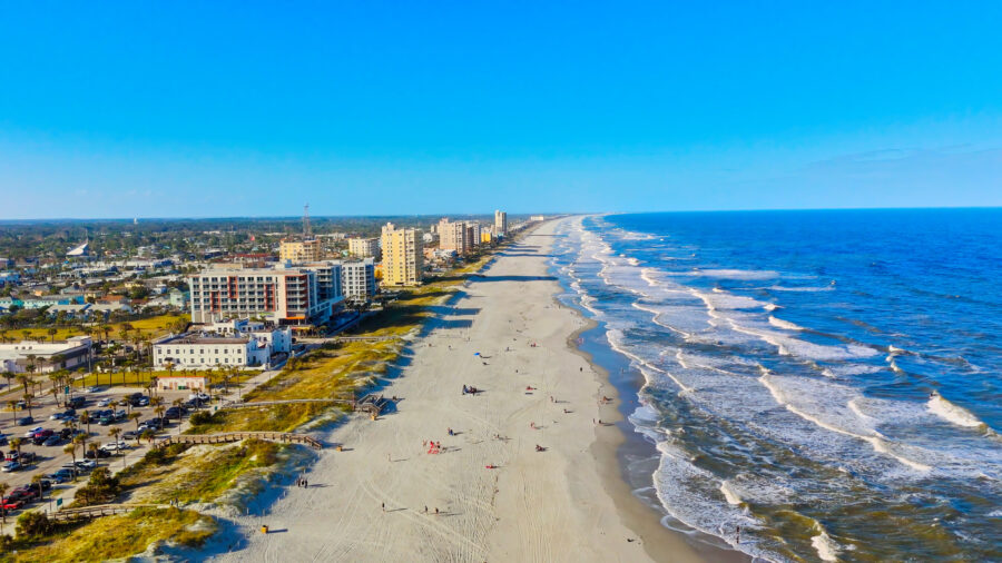Aerial view of Jacksonville Beach, Florida, showcasing sandy shores, waves, and beachgoers from a drone perspective