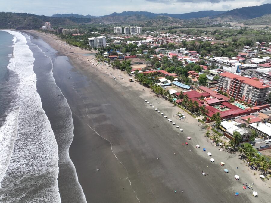 Aerial view of Jaco Beach, Costa Rica, showcasing its stunning coastline, lush greenery, and vibrant blue ocean