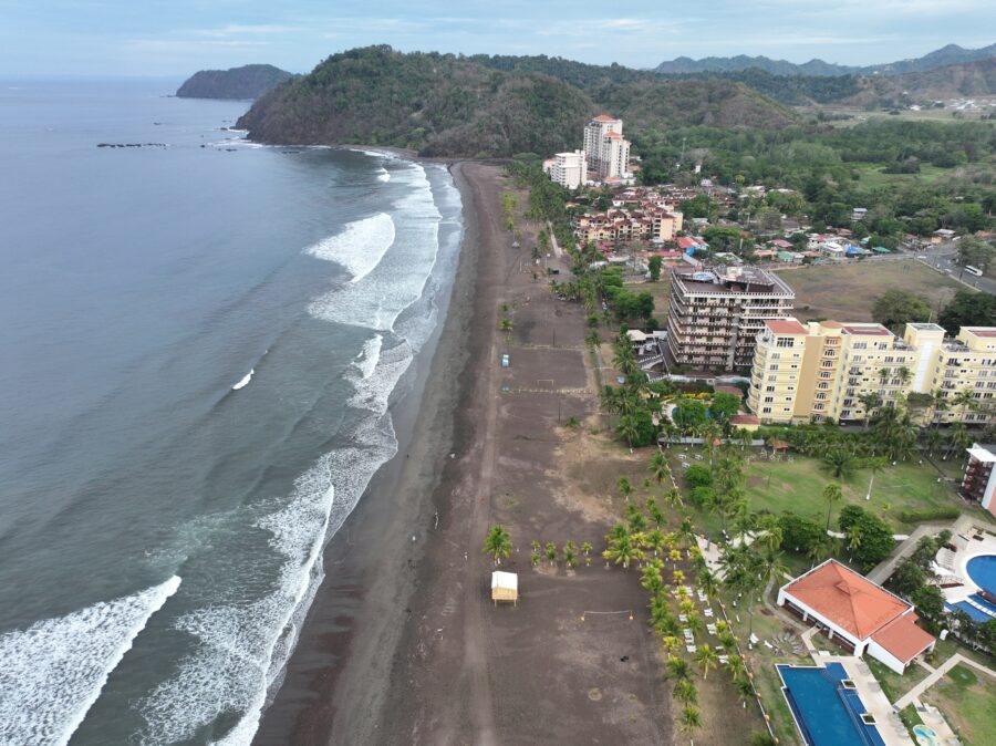 Panoramic aerial image of Jaco Beach, Costa Rica, highlighting the lush landscape and serene ocean waves