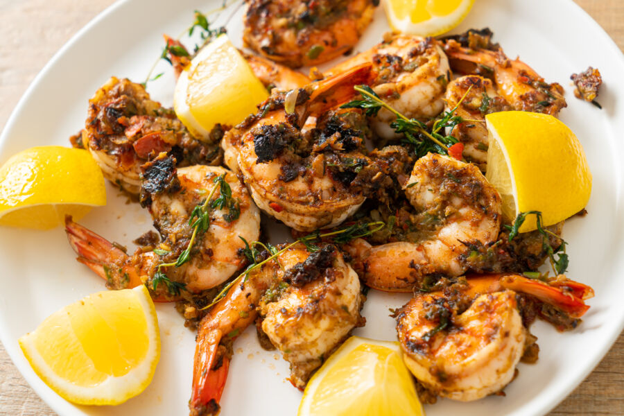 Delicious Jamaican jerk shrimp, perfectly grilled, served with lime wedges and a sprinkle of fresh herbs for added flavor