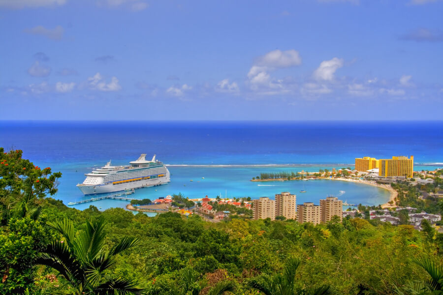 Beautiful Caribbean landscape of Jamaica featuring a cruise ship sailing in the clear blue sea