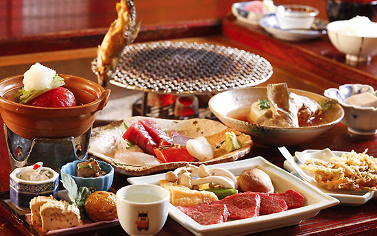 Traditional Japanese kaiseki dinner with tabletop grill, raw wagyu beef, sashimi, and simmered dishes.