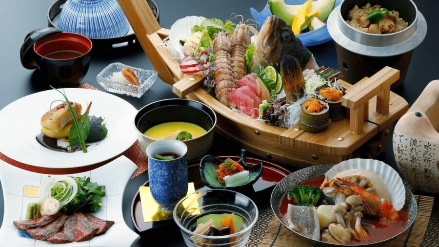 Japanese dining: sashimi boat, fish, chawanmushi, rice, and pickled veggies.
