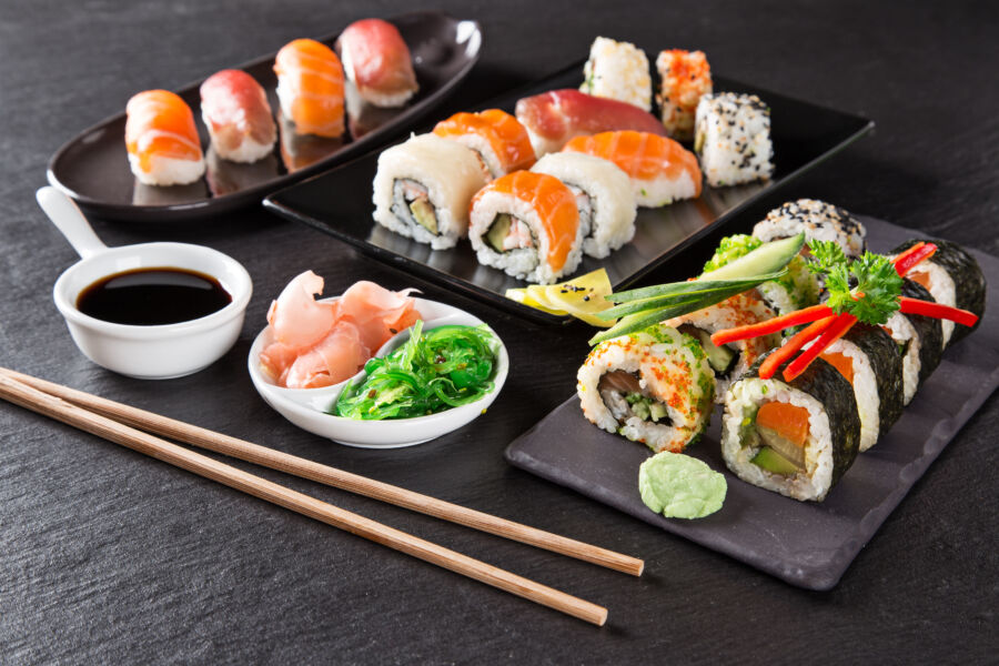 Traditional Japanese seafood sushi set with a variety of nigiri and maki rolls, artfully presented on a bamboo mat.