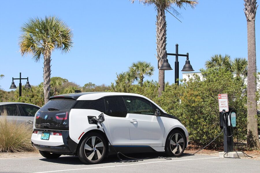 BMW i3 electric vehicle plugged into a charging station, highlighting sustainable travel on Jekyll Island.