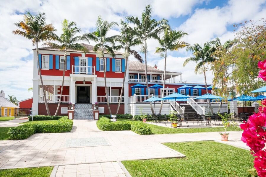 The National Art Gallery of The Bahamas features a large white house with a wide porch and lush trees nearby.