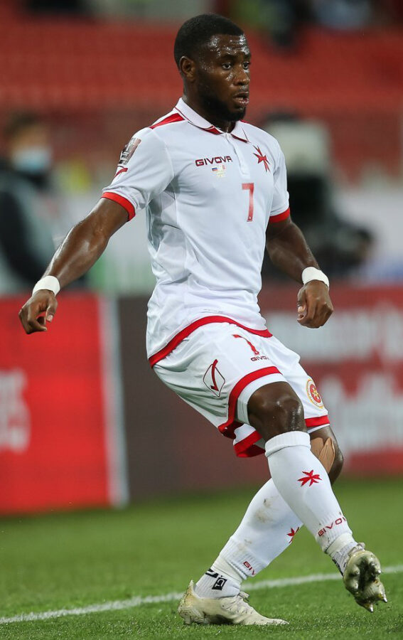 Joseph Mbong, a Maltese footballer, is playing as a wing-back on the field during a match.
