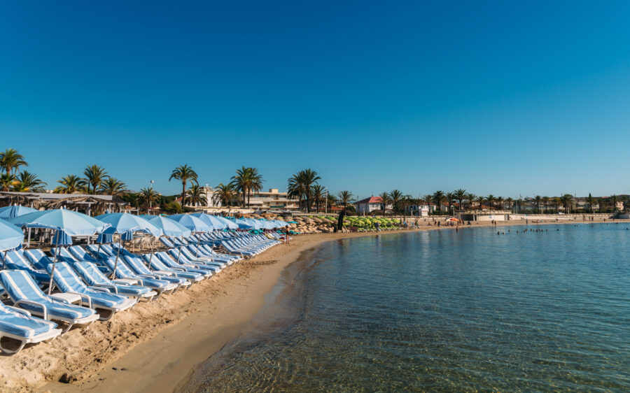 Empty beach lounges sit in neat rows on the sandy beach of Juan les Pins, France, inviting relaxation under the sun