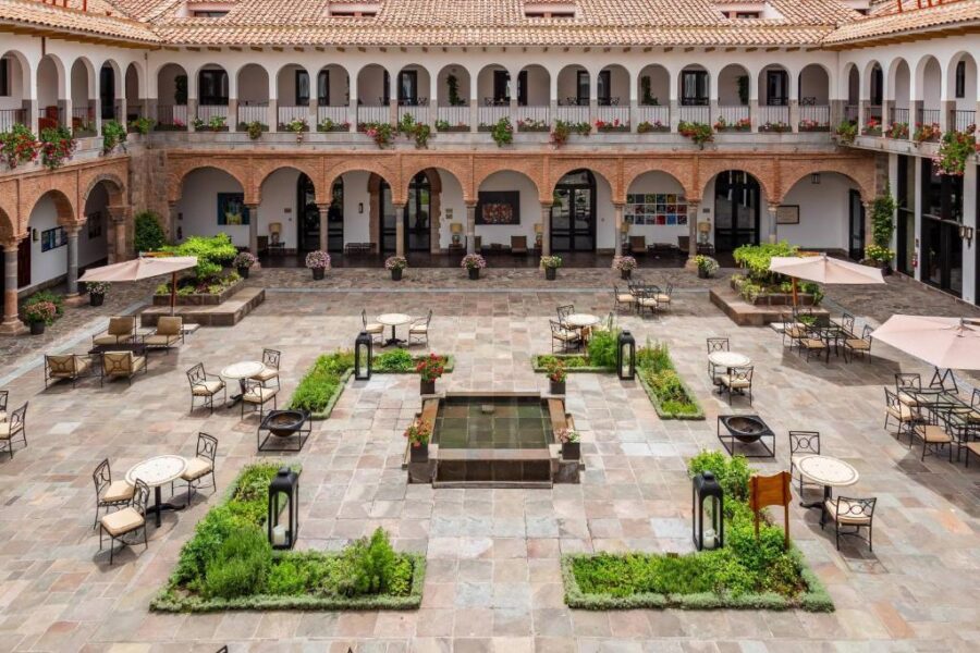 Courtyard of JW Marriott El Convento hotel in Cusco, Peru, featuring lush greenery and elegant seating areas.