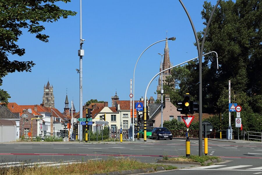 Street scene featuring a traffic light and the Katelijnepoort church in Bruges.