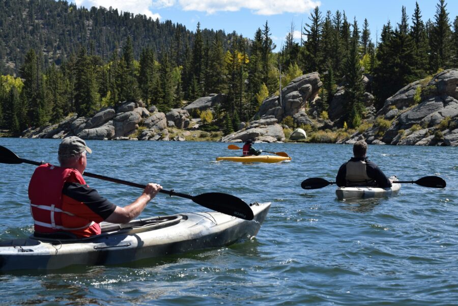 Kayaking adventure on a peaceful lake surrounded by autumn trees and mountains.