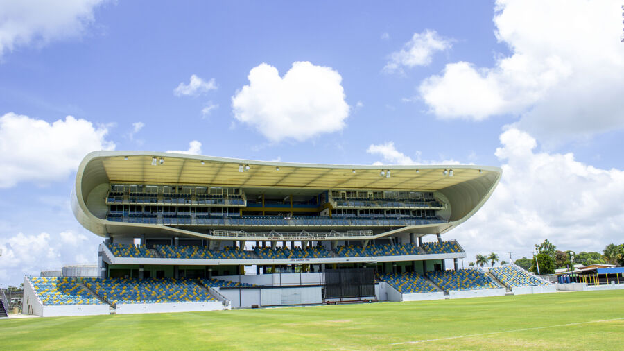 Exterior view of Kensington Oval in Barbados, showcasing its architecture against a backdrop of the skyline