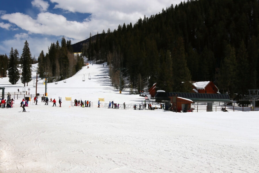 Sunny spring day at Keystone ski resort in Colorado, showcasing skiers enjoying the slopes and clear blue skies