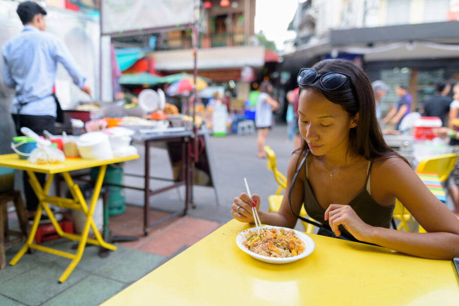 Woman eating Pad Thai noodles at Khao San road