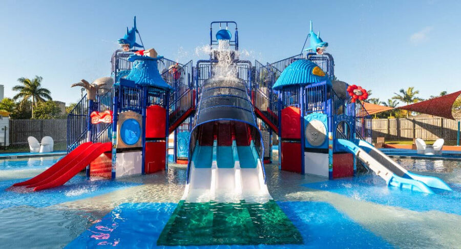Colorful kids water playground with slides and splash bucket at Sunshine Coast family resort pool.