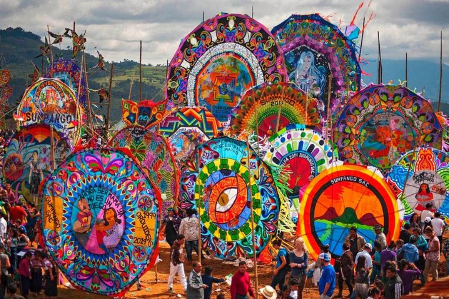 Colorful kites soar at a vibrant festival in Guatemala, celebrating cultural traditions and community.