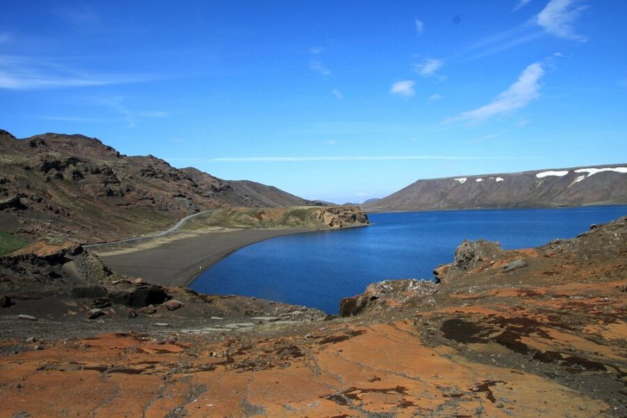 Kleifarvatn Lake nestled among towering mountains and rocky landscapes, showcasing natural beauty.
