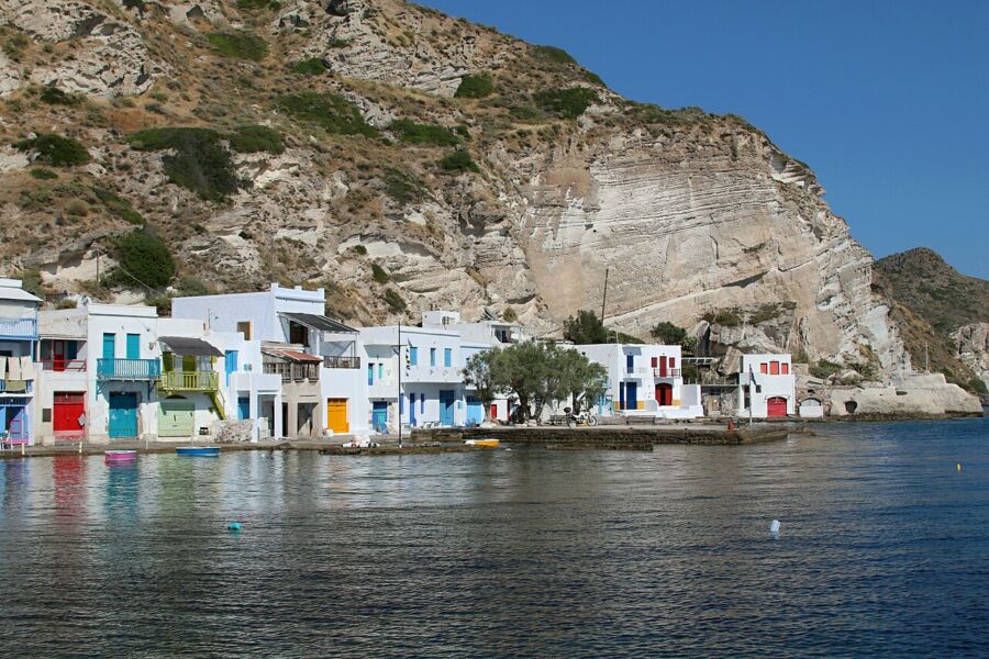 Serene body of water in Klima, Milos, Greece, reflecting the clear blue sky and surrounding landscape.