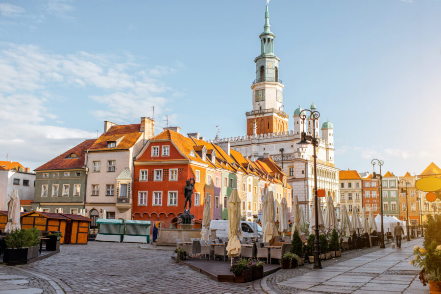 Krakow Market Square with colorful townhouses and town hall in morning light.