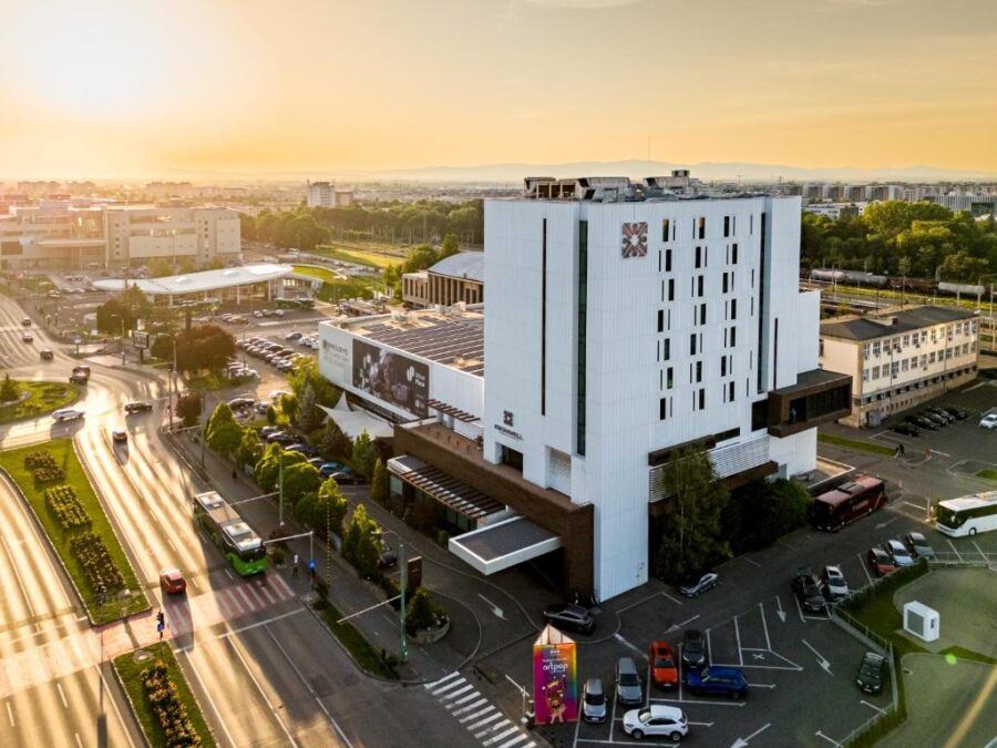 Kronwell Brasov Hotel, a prominent white structure, stands in the bustling city of Brasov, Romania.