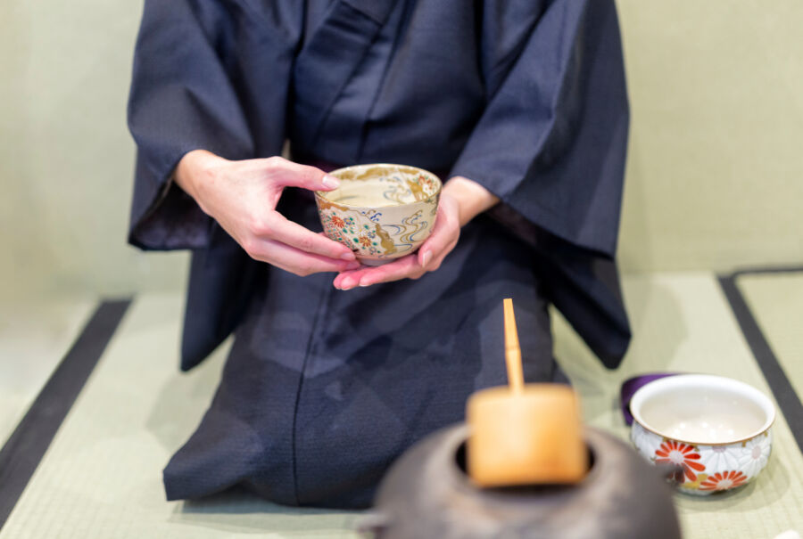 Inside a Kyoto ryokan, a man meticulously prepares for a traditional tea ceremony, embodying Japanese cultural heritage