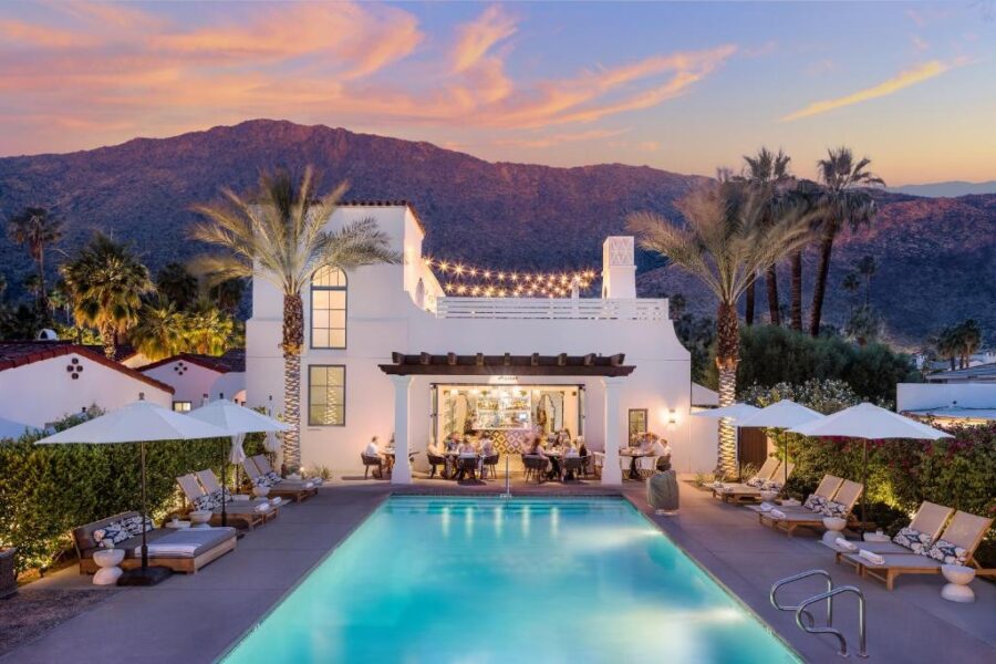 The inviting pool area at La Serena Villas, featuring palm trees and comfortable seating in the heart of Palm Springs.

