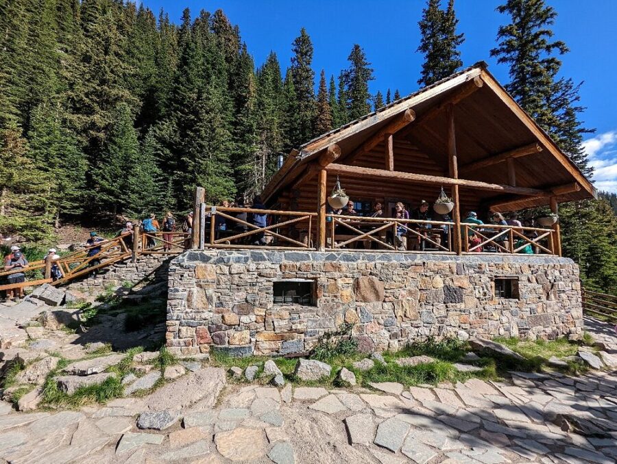 Visitors gather outside the Lake Agnes Tea House restaurant, set against the beautiful mountain backdrop in Banff National Park.
