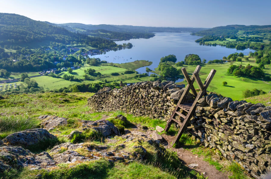 Morning view of Lake Windermere with stone walling and a stile for crossing in Lake District National Park, Cumbria, England.