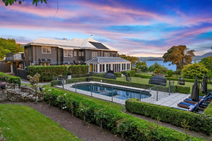Luxury lakeside boutique hotel with pool, garden, and sunset views over the water.