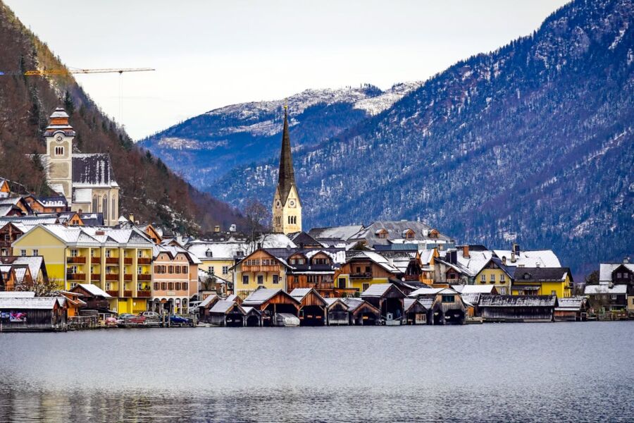 Charming alpine village with snow-capped mountains, tranquil lake, and picturesque winter scenery.