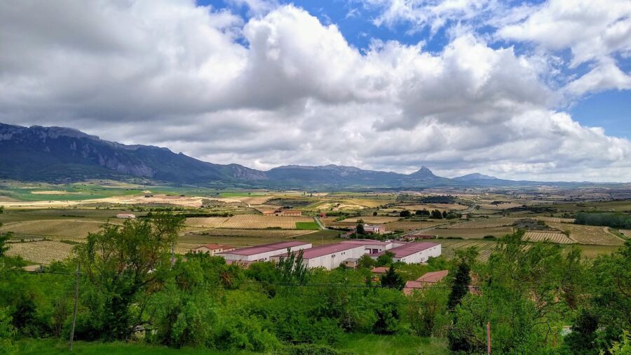 Scenic La Rioja rural landscape with mountains, lush greenery, and cultivated fields under dynamic skies.
