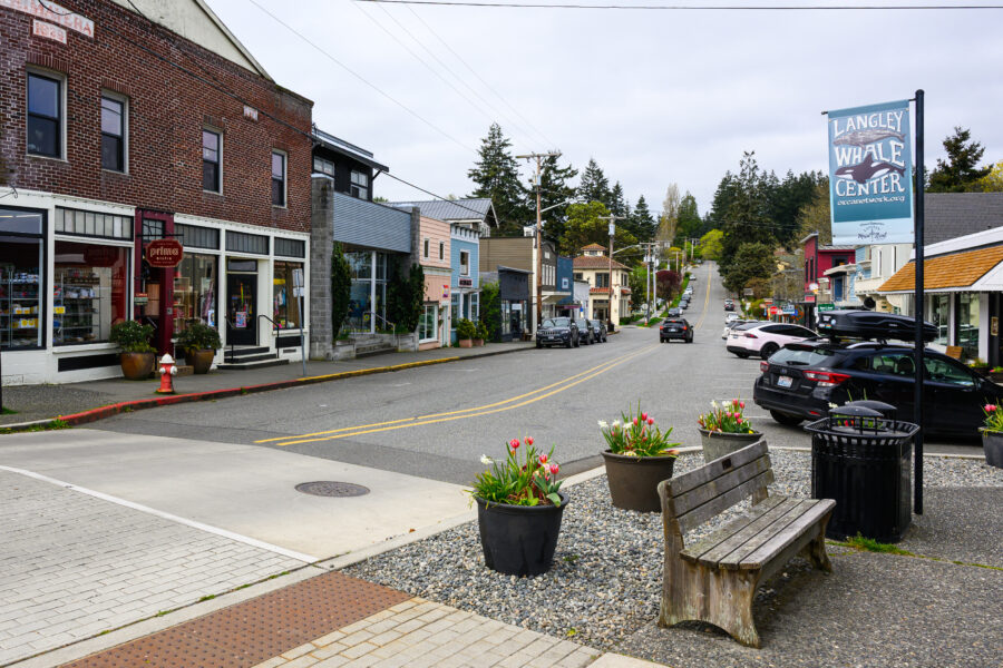 Scenic cityscape of Langley on Whidbey Island, featuring 1st Street lined with shops and greenery.