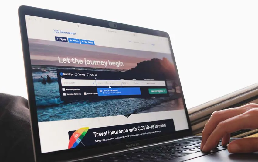 MacBook Pro displaying Skyscanner site for travel planning with natural light ambiance.