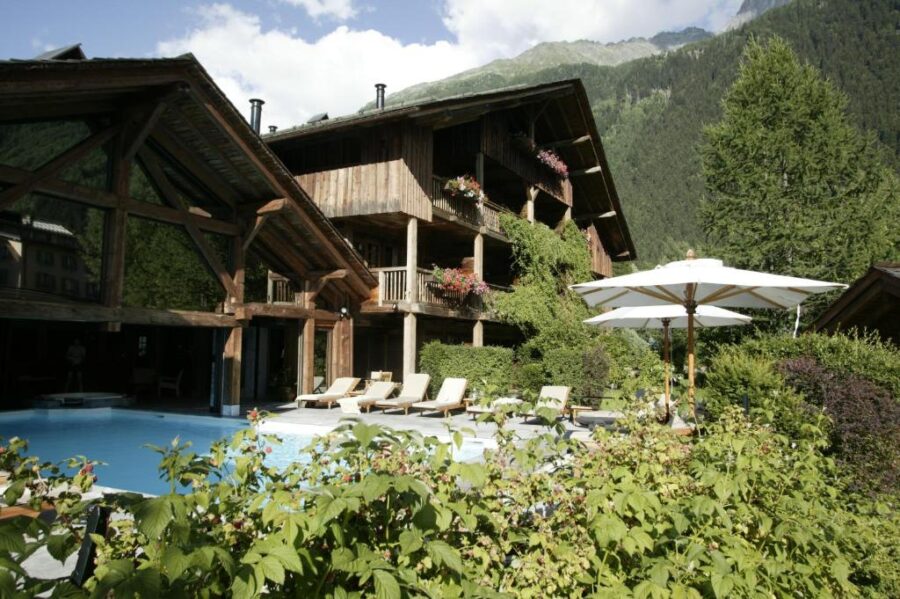 Spacious wooden accommodation featuring a pool, overlooking mountains at Le Hameau Albert 1er, Relais & Châteaux, Chamonix.