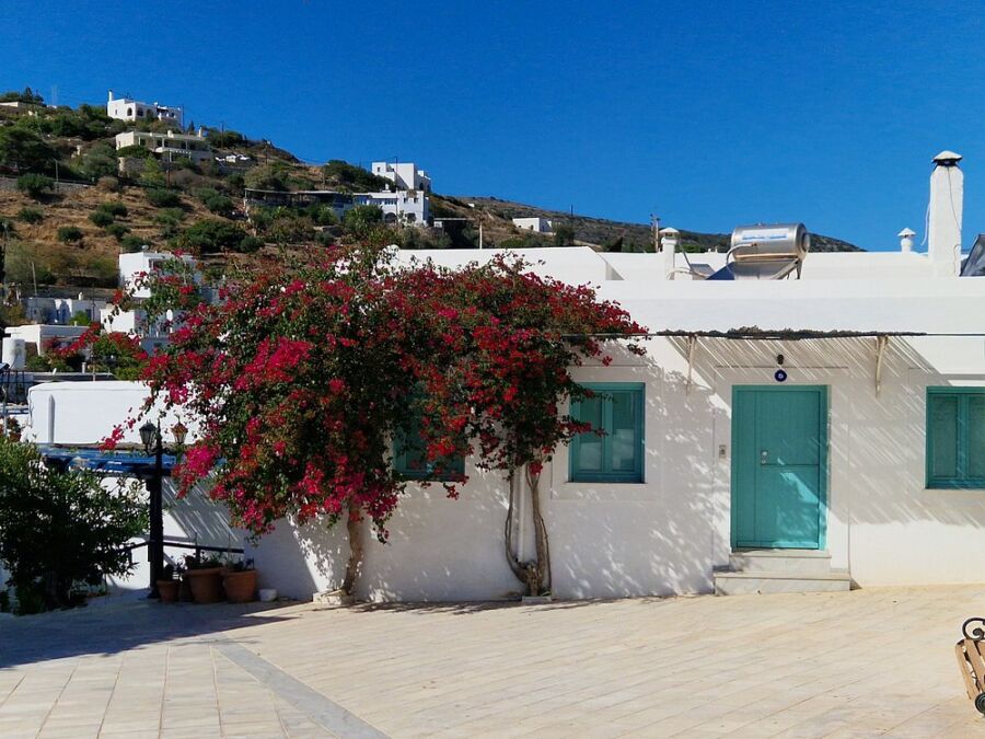 Picturesque white house with blue doors, set in the scenic village of Lefkes, Greece.