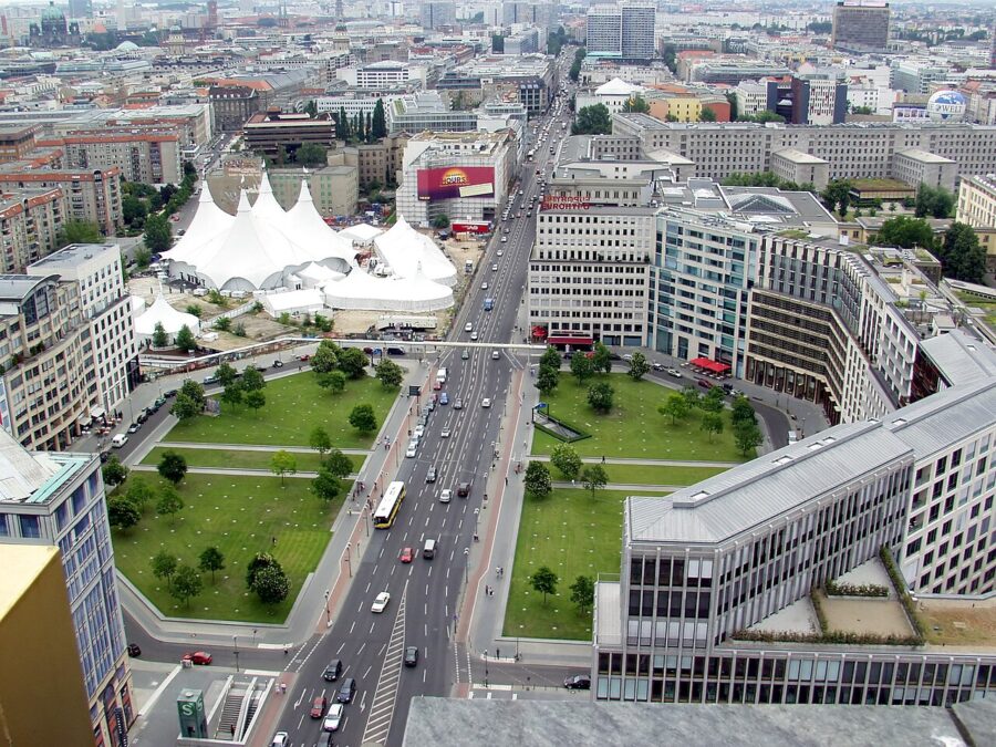 Aerial view of Leipziger Platz Berlin showing boulevard, green lawns, pedestrian bridge, and traffic.