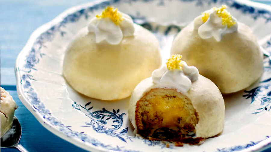 Lemon curd mini cakes with whipped cream and lemon zest.