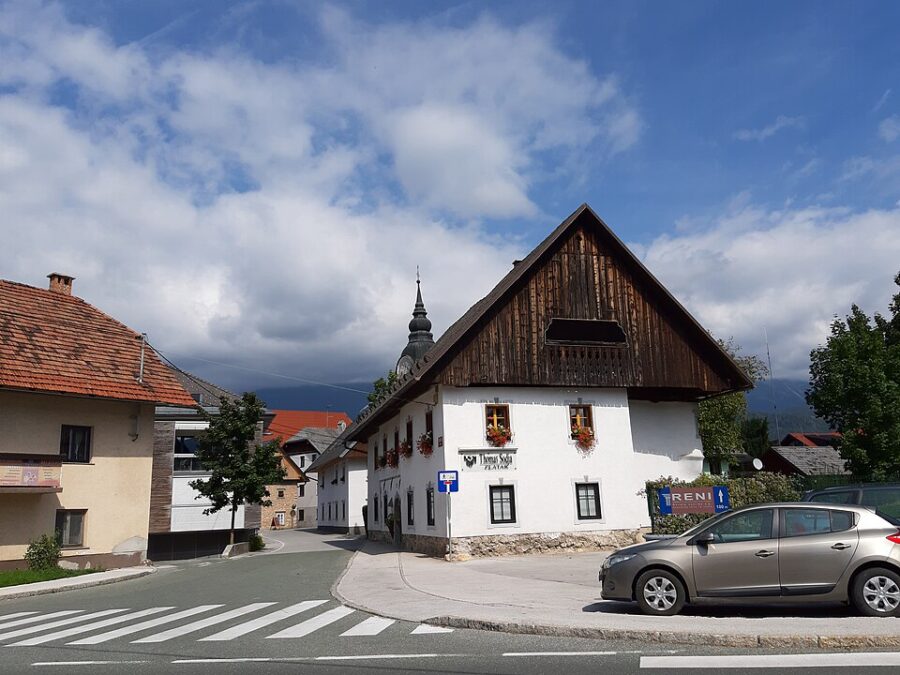 Parked car in front of a building in Lesce, Slovenia, showcasing the local architecture and urban setting.