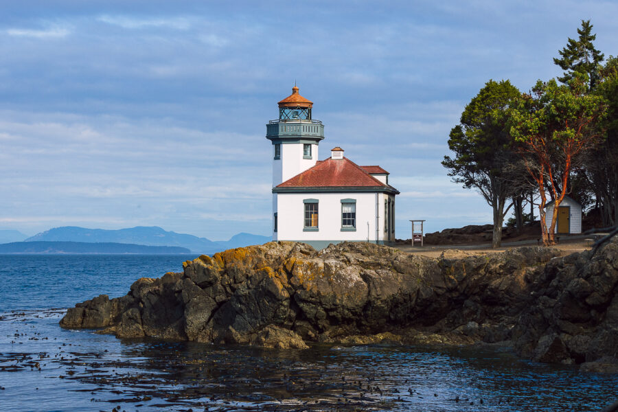 Scenic view of a lighthouse on the San Juan Islands, Washington, with the ocean and islands visible in the background.