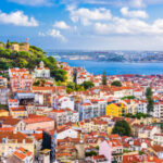 The skyline of Lisbon, Portugal, featuring a blend of traditional and contemporary structures under a bright sky
