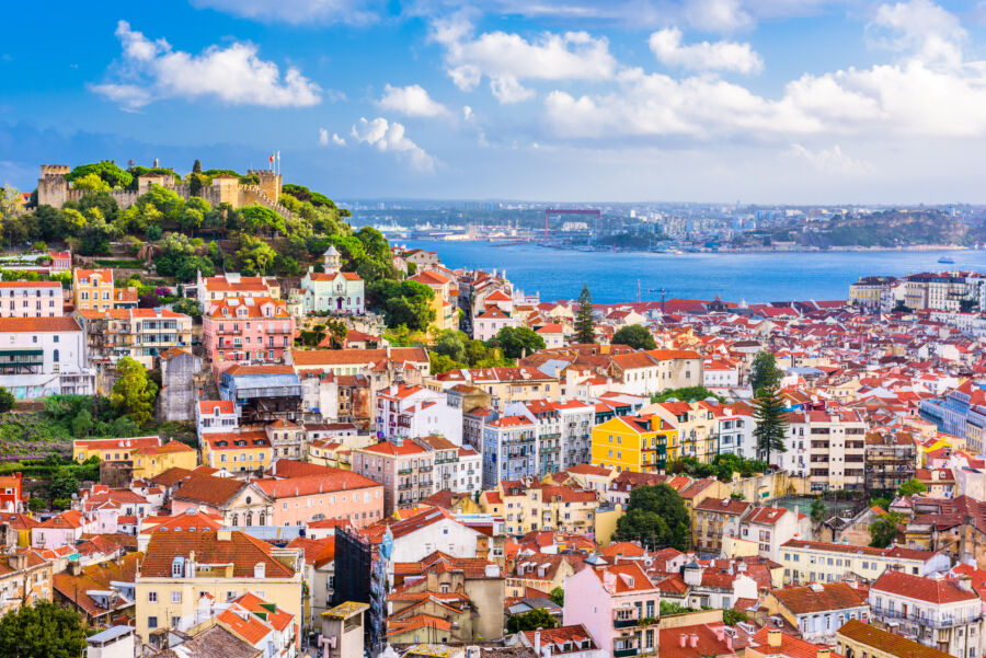 The skyline of Lisbon, Portugal, featuring a blend of traditional and contemporary structures under a bright sky