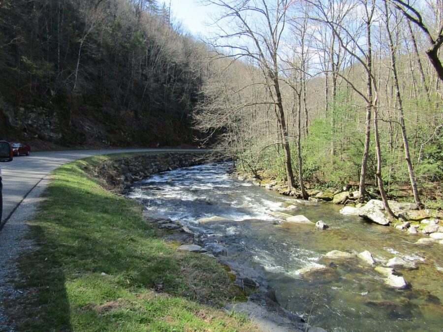 Little River Road in Tennessee, adjacent to a flowing river under a clear sky.