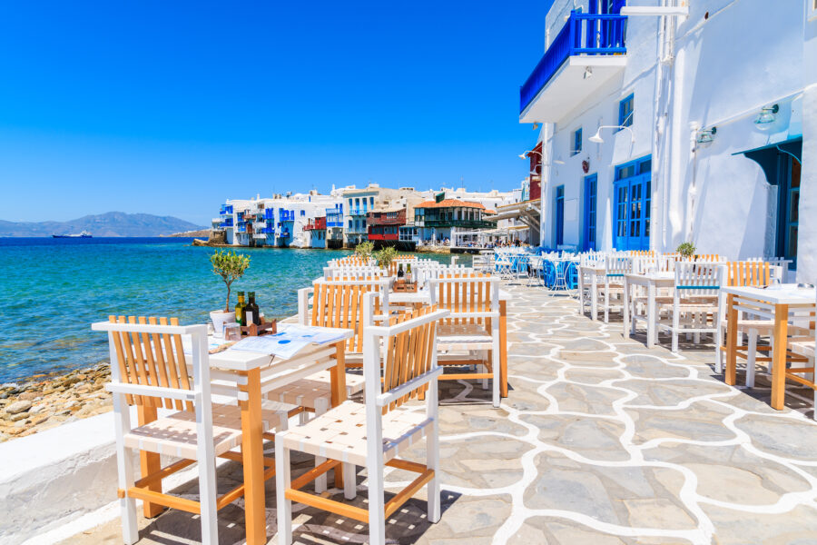 Outdoor seating with colorful chairs and tables in a traditional Greek tavern in Little Venice, Mykonos, Greece