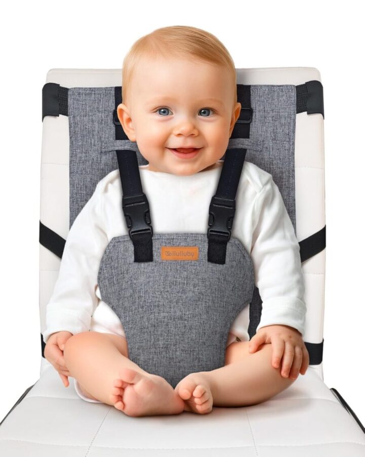 Baby comfortably secured in a grey and black Liuliuby Travel Harness High Chair featuring an adjustable harness.