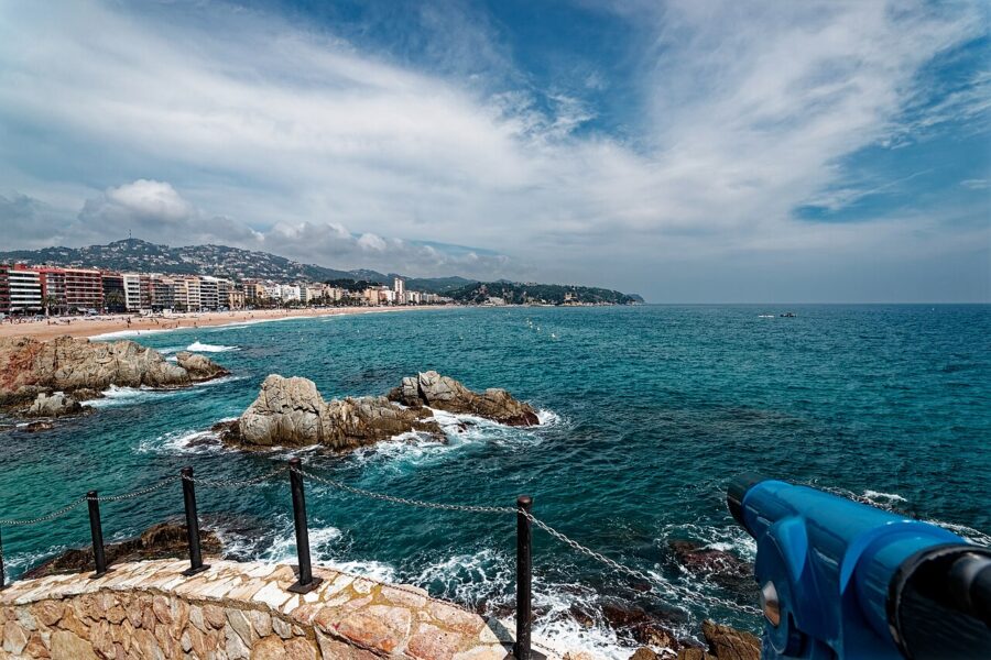 Blue telescope gazes out over the ocean, showcasing the scenic panorama of Lloret de Mar, Spain.