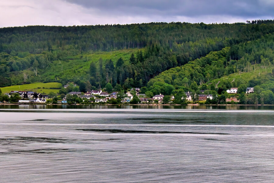 Waters of Loch Ness, framed by a scenic town in the background.