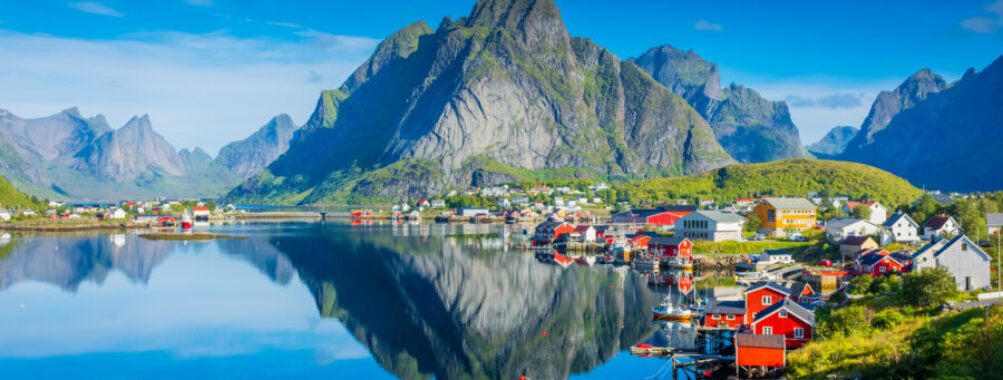 Stunning reflection of Reine village mirrored in the tranquil fjord waters of Norway's Lofoten Islands.