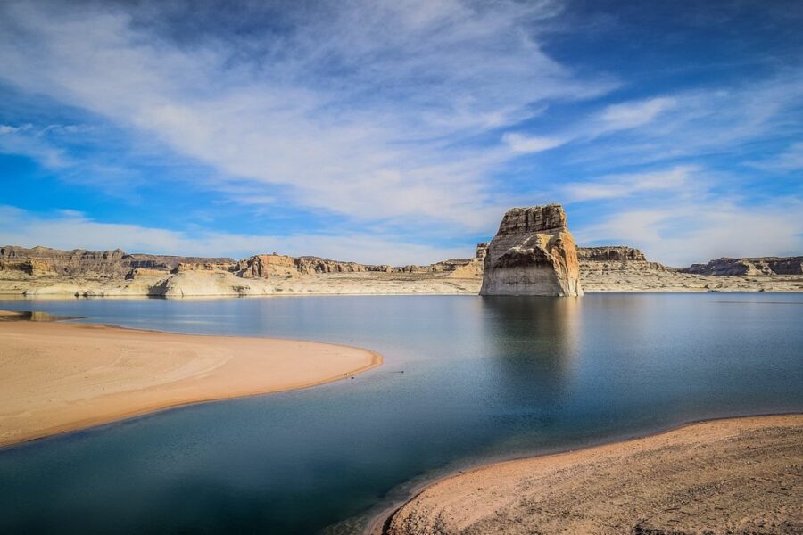 Scenic view of Lake Powell at Lone Rock Beach, showcasing vibrant blue water and surrounding red rock formations.