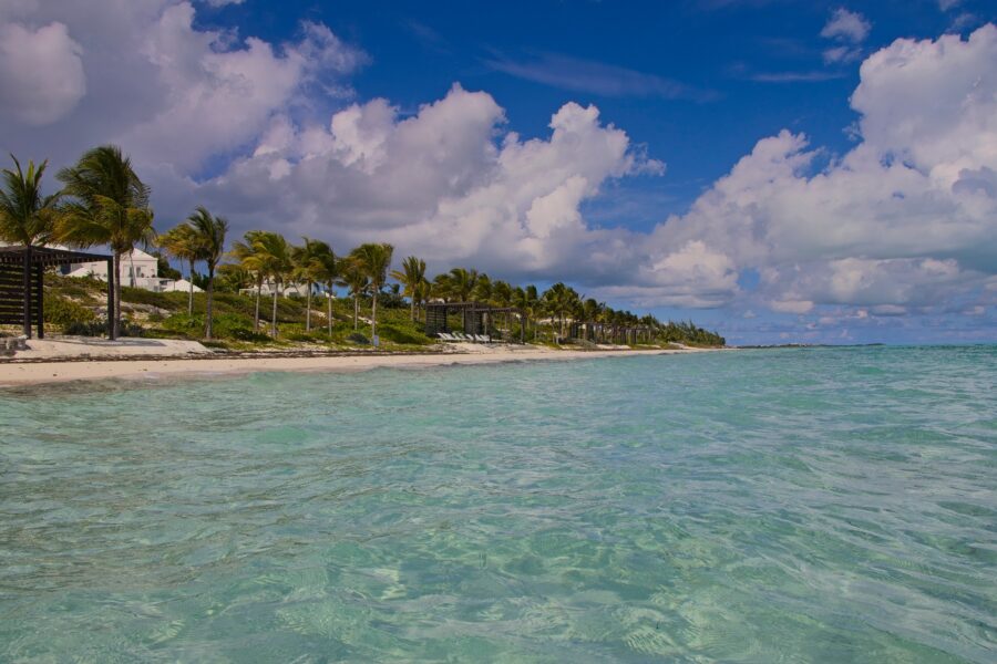 People splashing and splashing in the warm, colorful waters of Long Bay Beach in the Turks and Caicos Islands.