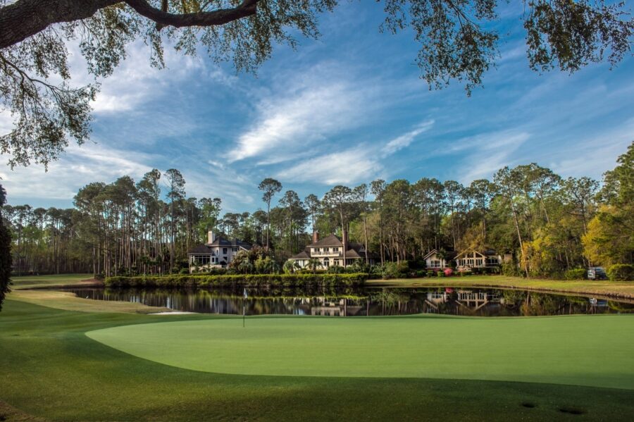 Scenic view of the 18th hole at Long Cove Club, Hilton Head, showcasing a well-manicured green and surrounding landscape.
